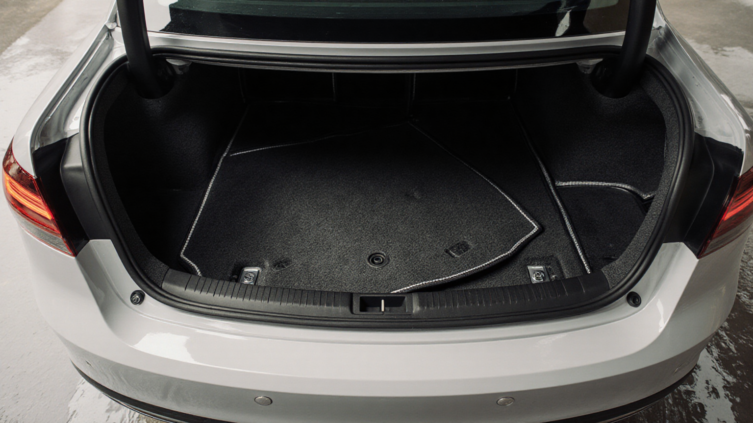 Open sedan trunk showing the cargo floor and spare-wheel cover